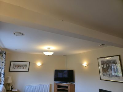 Ceiling ventilation and lighting in a modern living room, showcasing HVAC systems and ambient lighting.